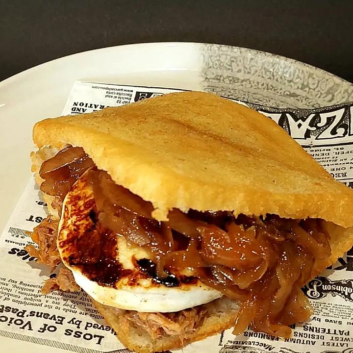 The Goat: arepa con carne mechada, rodaja de queso rulo de cabra y cebolla caramelizada